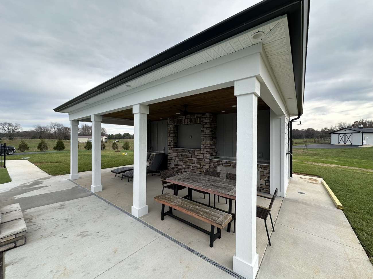 Covered pavilion with a stone fireplace and picnic tables