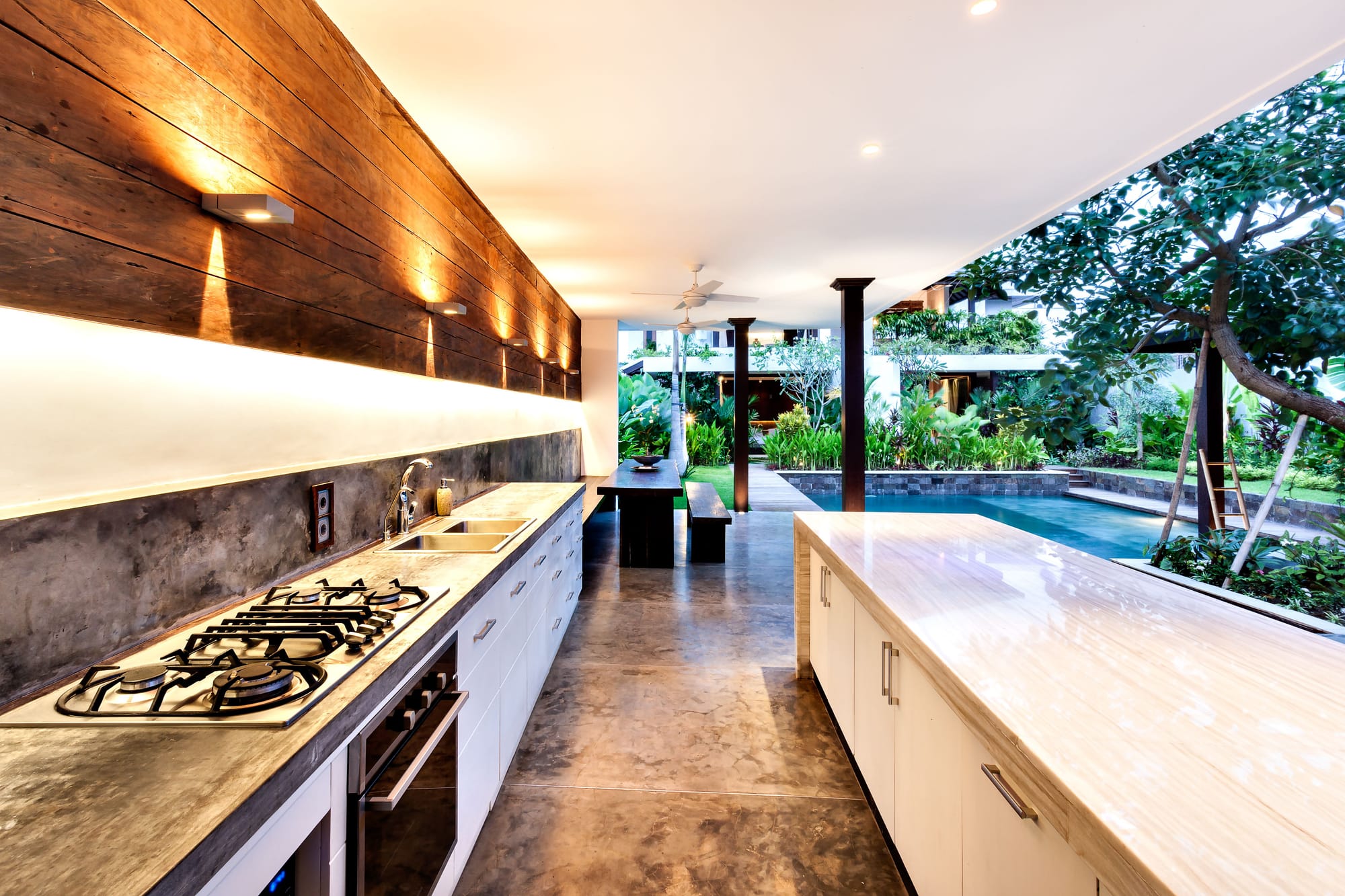 Outdoor kitchen with a gas cooktop and long stone countertop